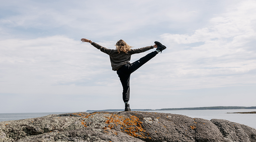 A photo of a woman posing on a cliff