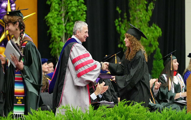 President Zupan shaking hands with a graduating student at Commencement
