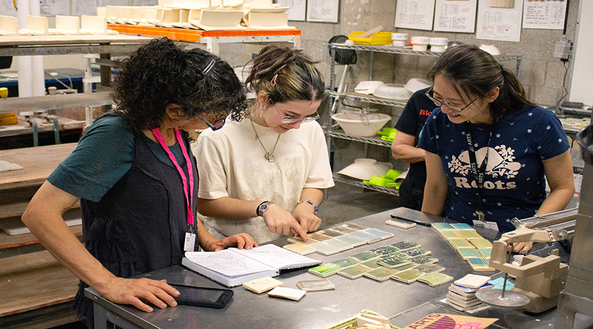 A photo of students glazing pottery