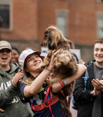 A girl holding a dog during Hot Dog Day