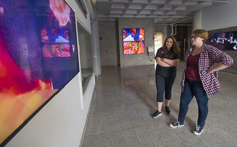 students looking at artwork on tv screen