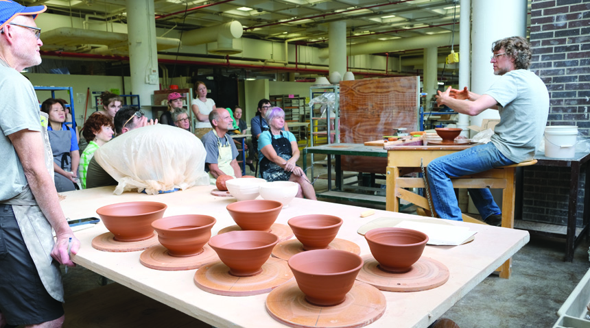 A photo of a professor teaching a ceramics program