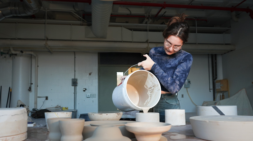 A student pouring plaster into a mold