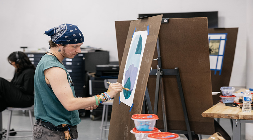 A student painting on a canvas