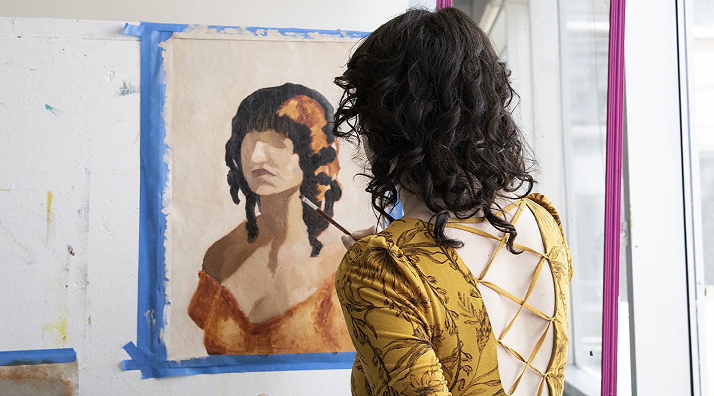 A student painting on a canvas