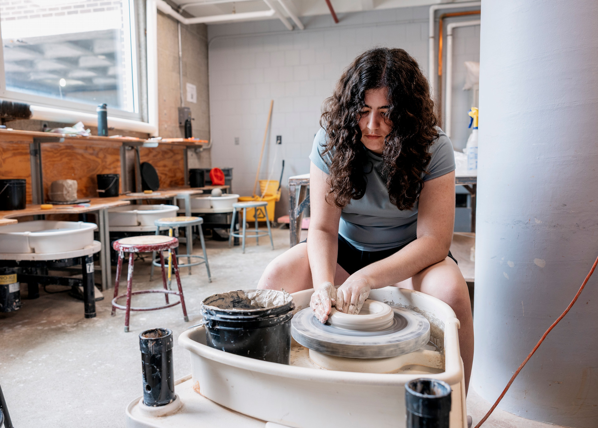 A photo of a student using a pottery wheel