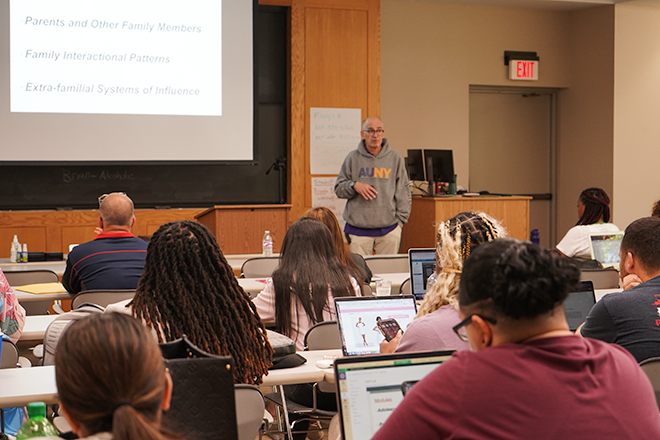 Group of AU-NYC students at a desk discussing classwork