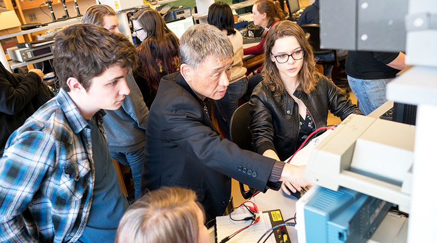 A photo of an engineering professor teaching students in a classroom