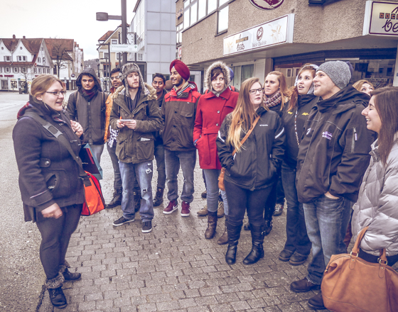 A group of Alfred University students listen to a guide during a study abroad trip in a European city.