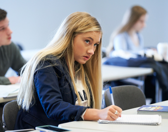 Female student in class taking notes