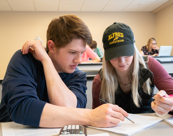 One student helping another student in class