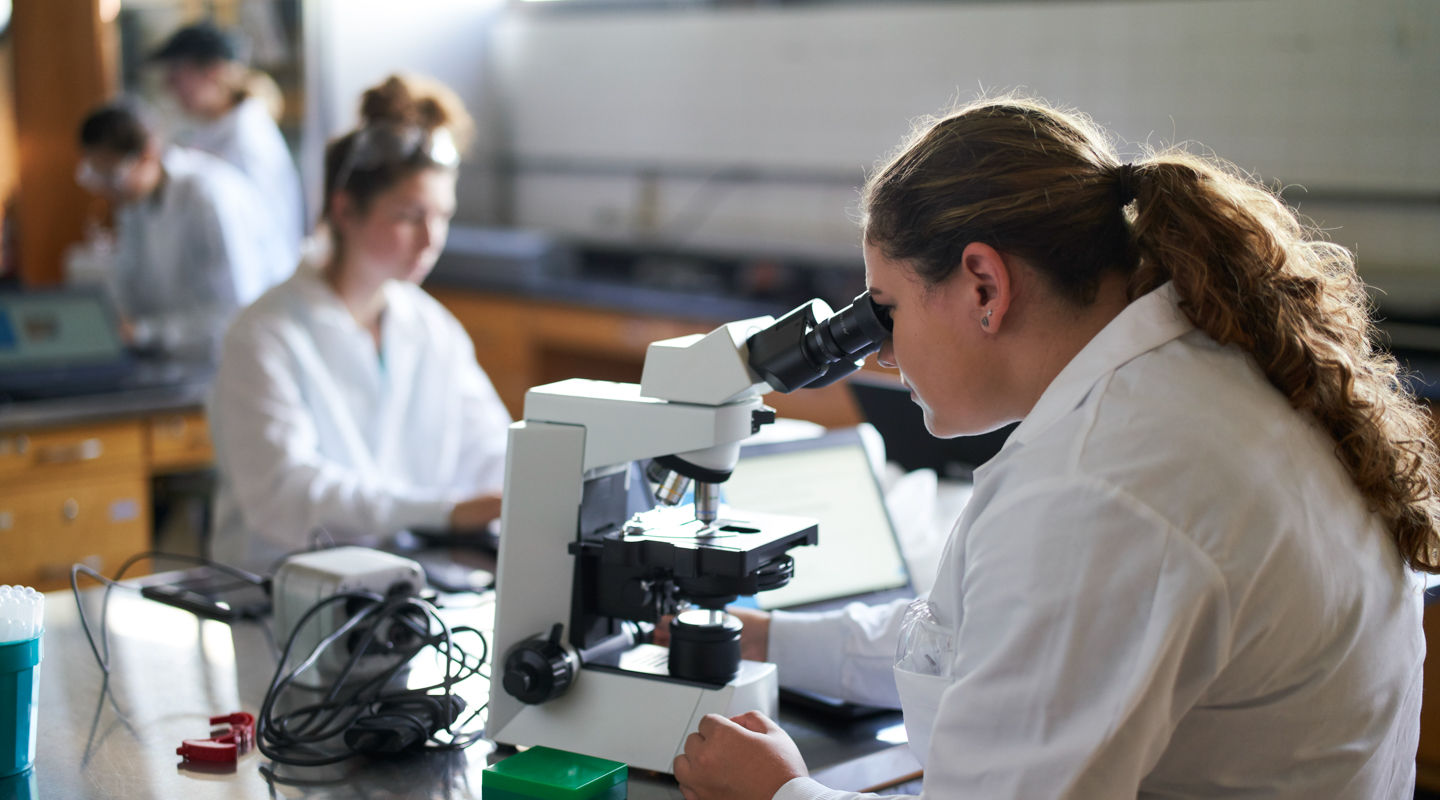 student using a microscope in the lab