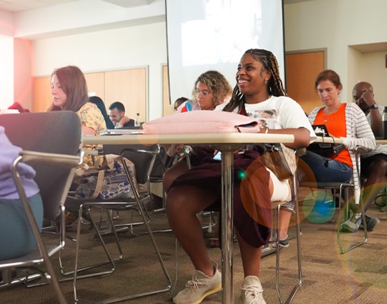 students in graduate program class laughing and smiling