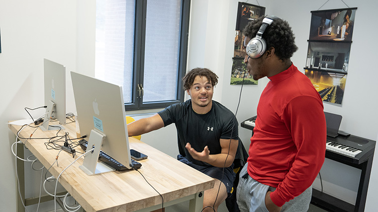 A photo of two students working together in a computer lab