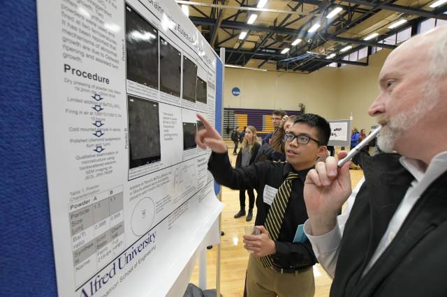 Student explaining their research project to faculty member 