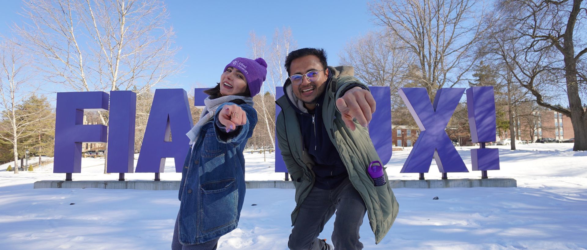 Two international students posing to the camera during snow on campus