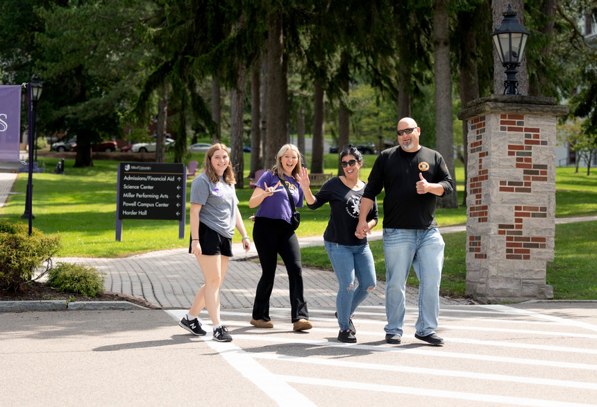A photo of a student walking on campus with their family