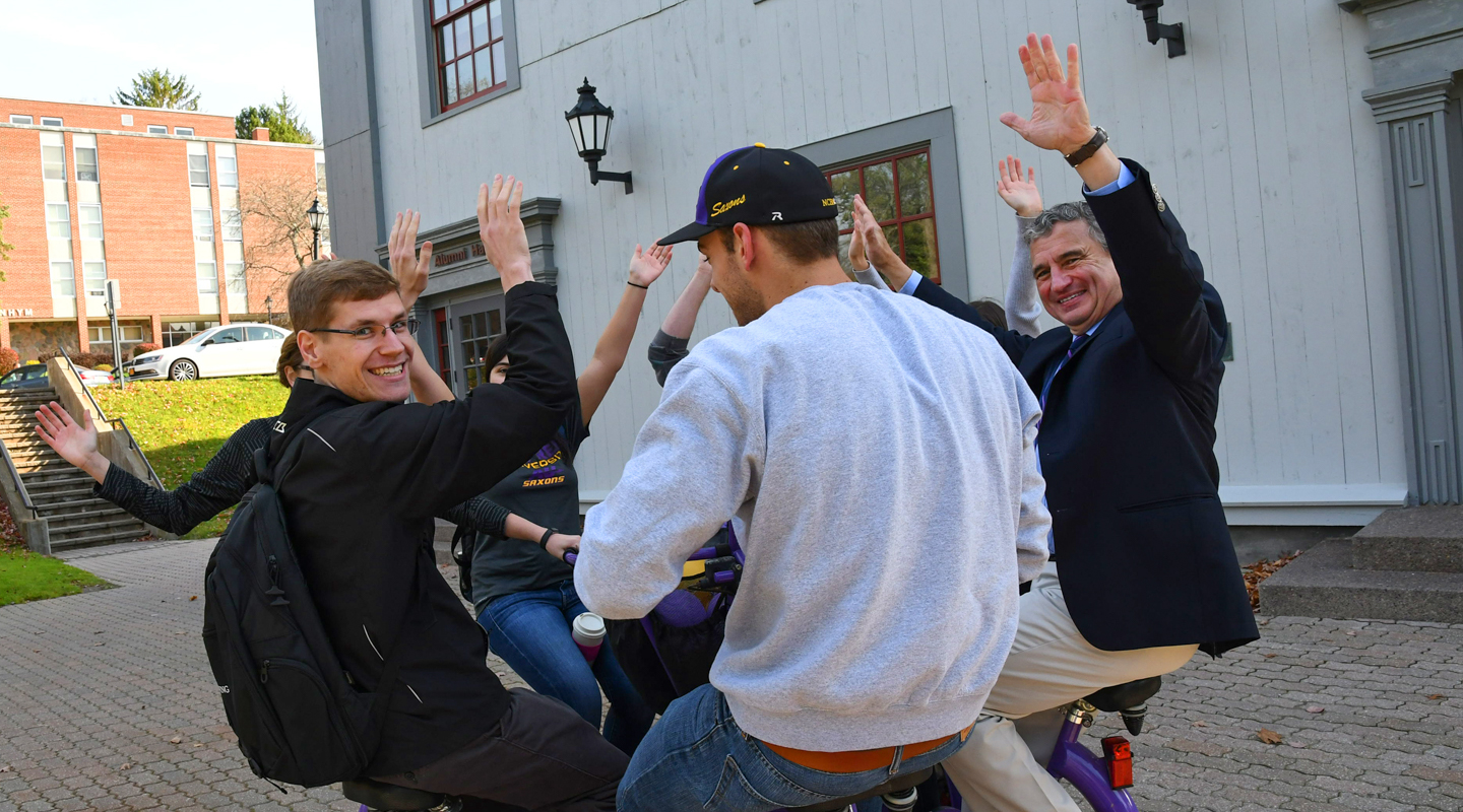 students and President Zupan riding a bike