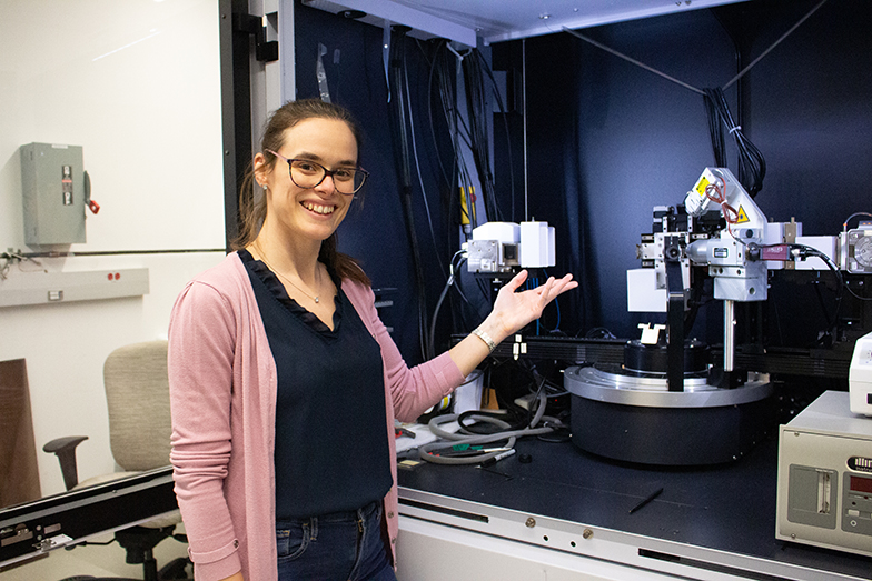 A student standing next to a engineering machine