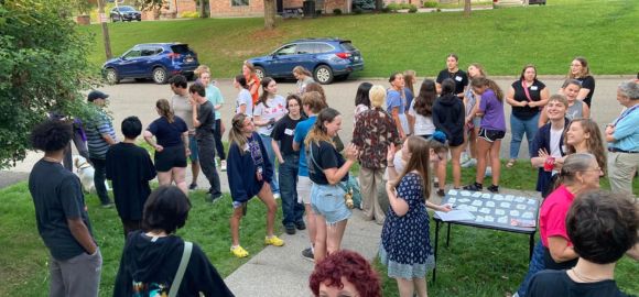 students gathered at an event on the lawn of a residence hall