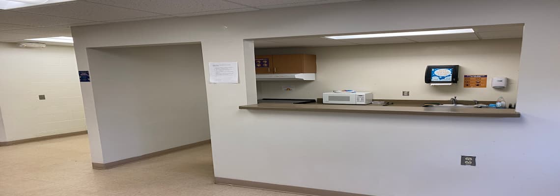 A kitchen area featuring a sink and a microwave, showcasing a functional and organized cooking space.