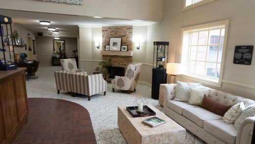 Cozy lounge area of the Saxon Inn with a fireplace, armchairs, and a large window letting in natural light.