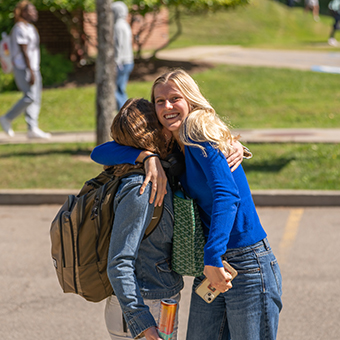 A photo of two students hugging each other