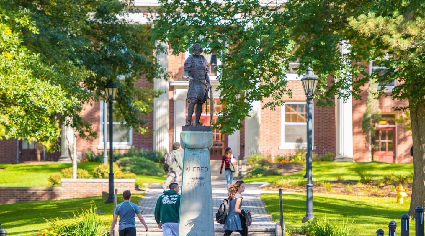 Students walking in the quad by the statue of King Alfred