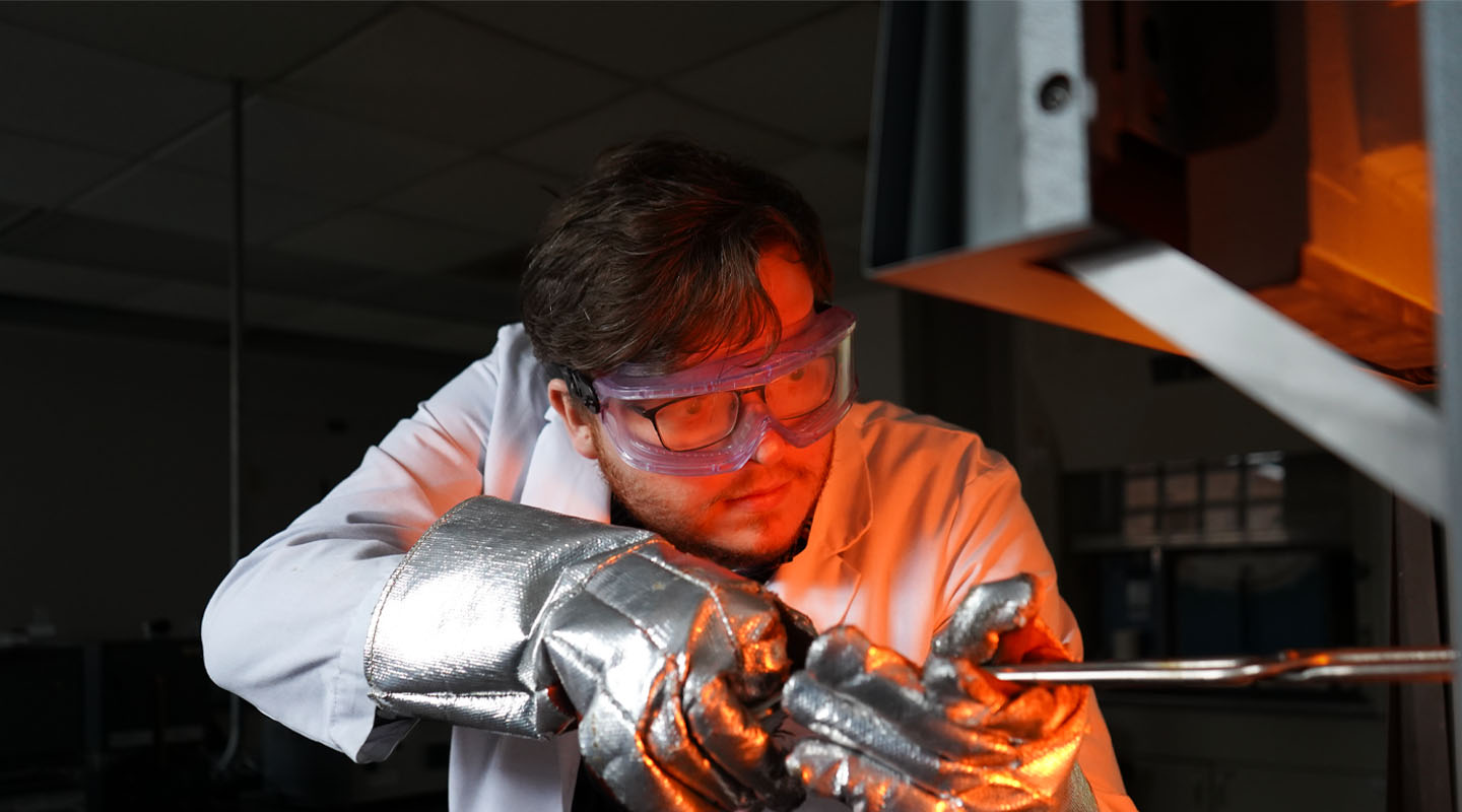 faculty member putting something ceramic in a kiln