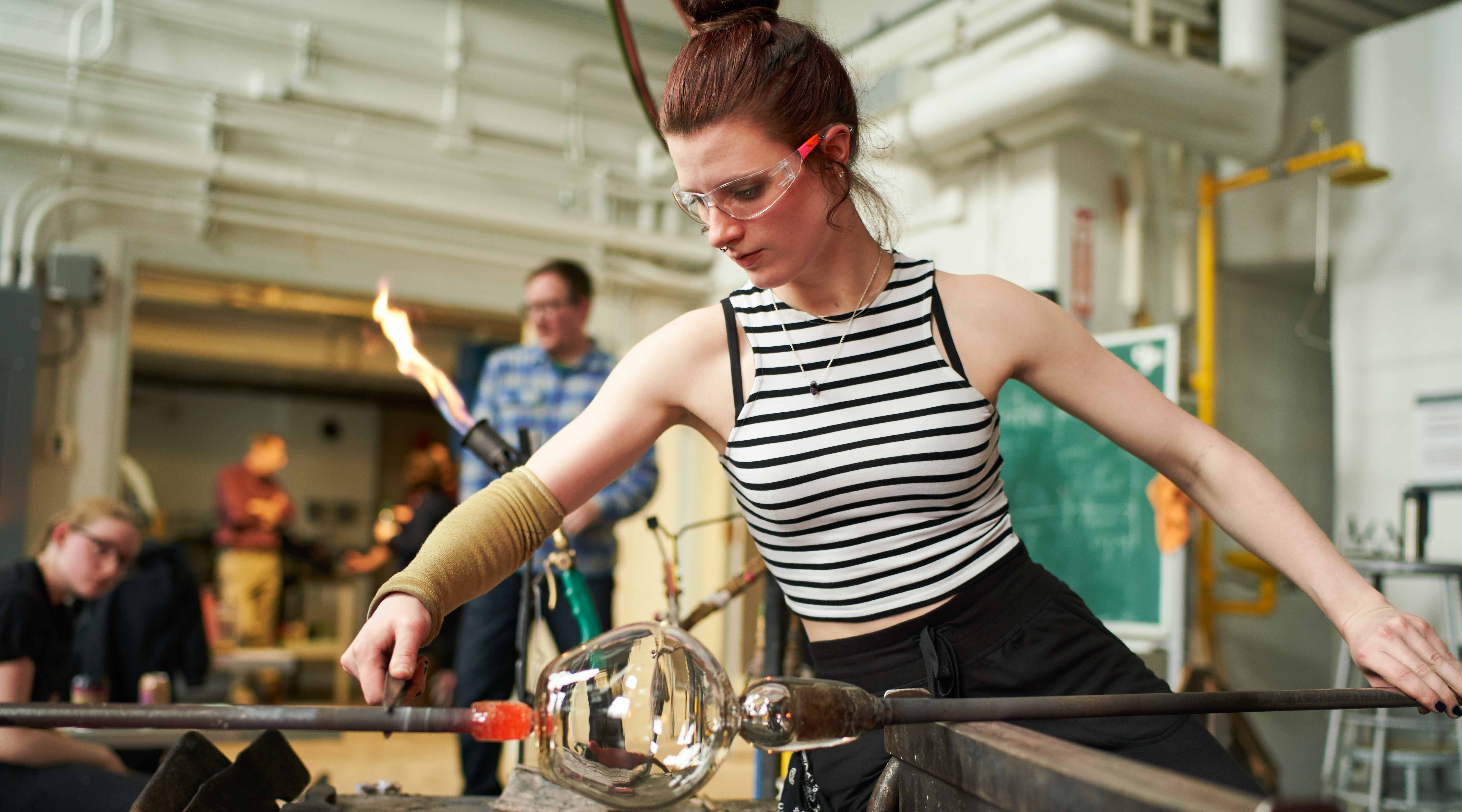 student creating glass sculpture