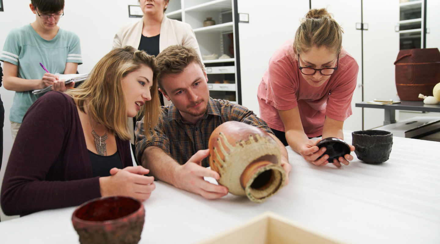Student looking at pottery