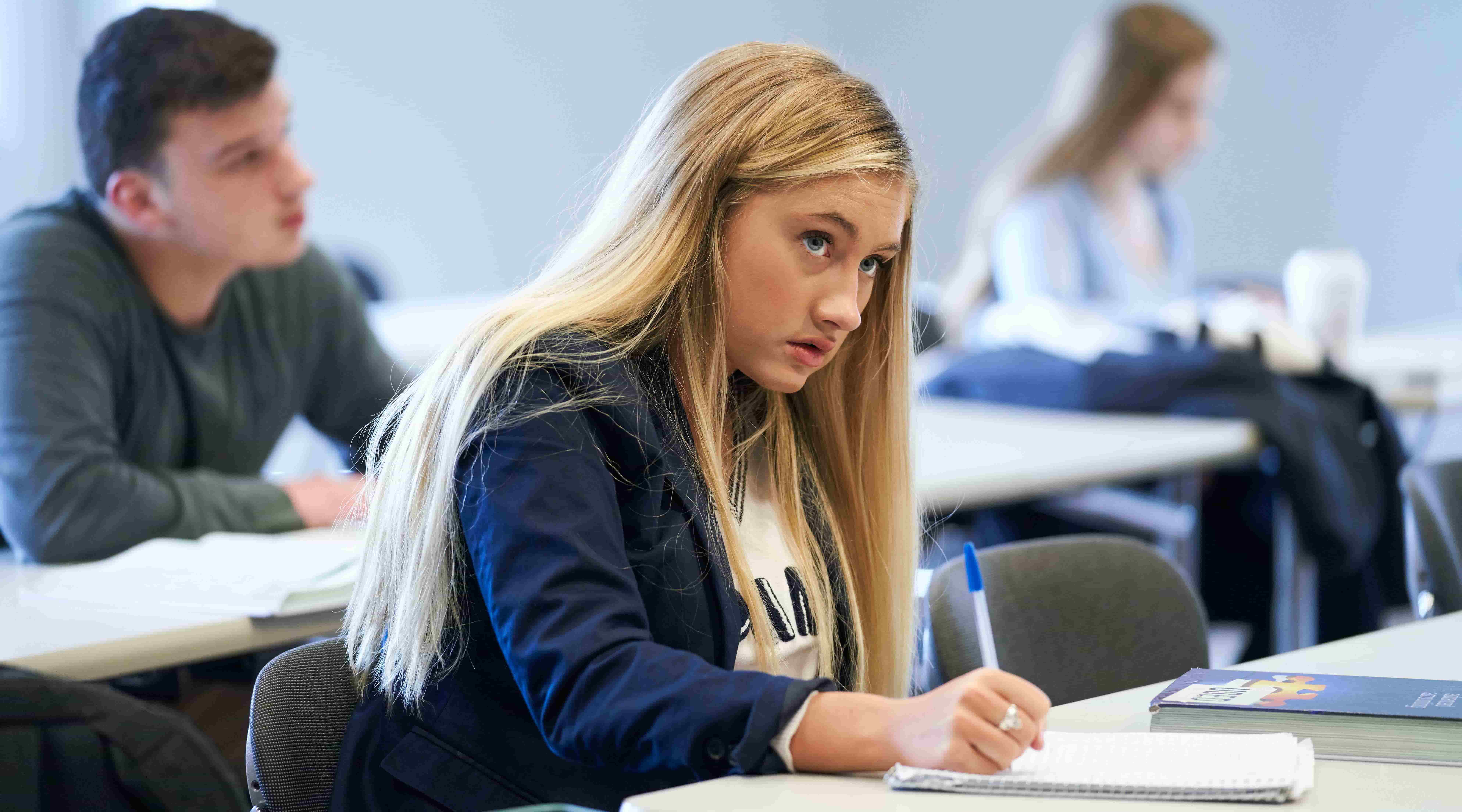 Female student taking notes in lecture hall