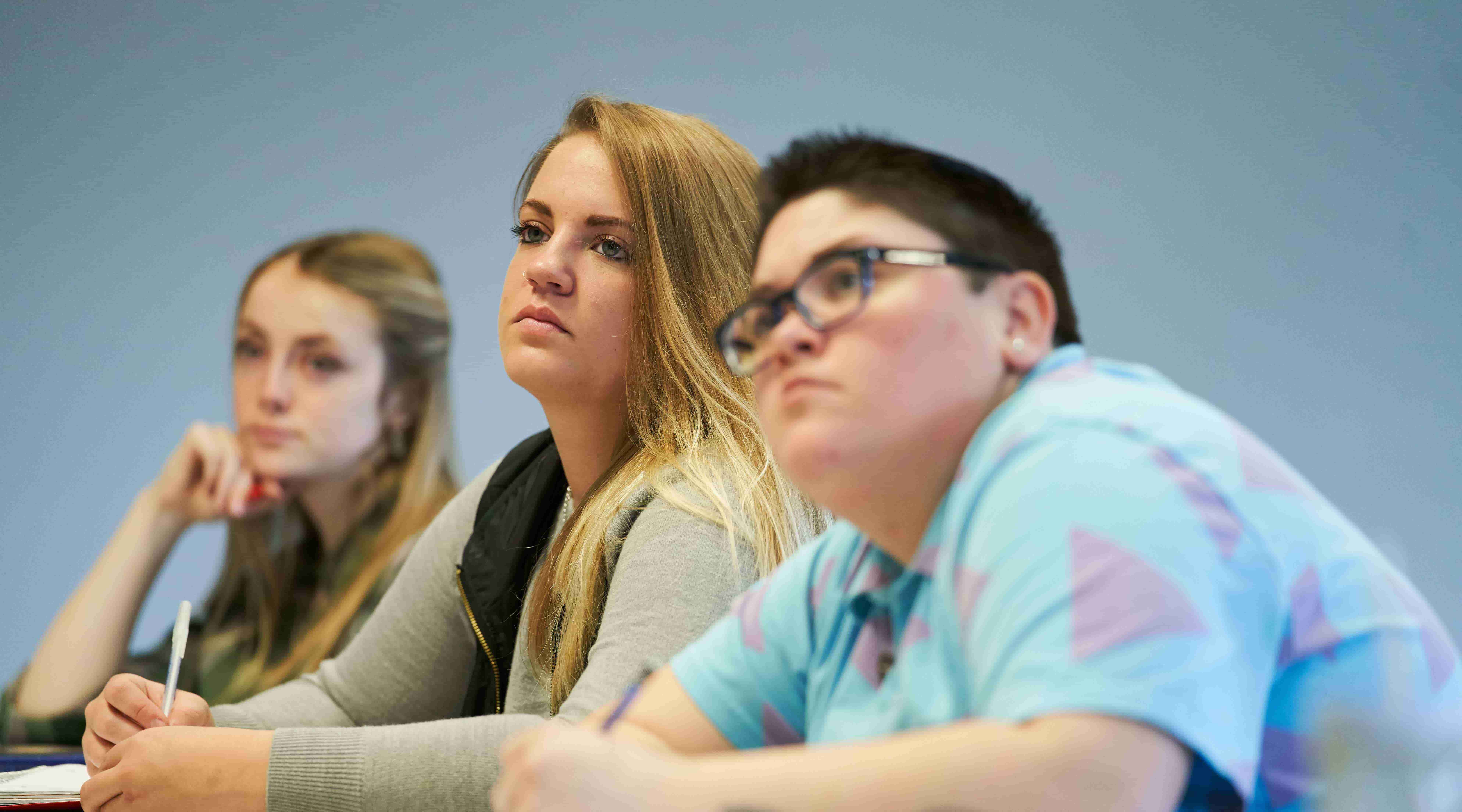 Three students listening to lecture