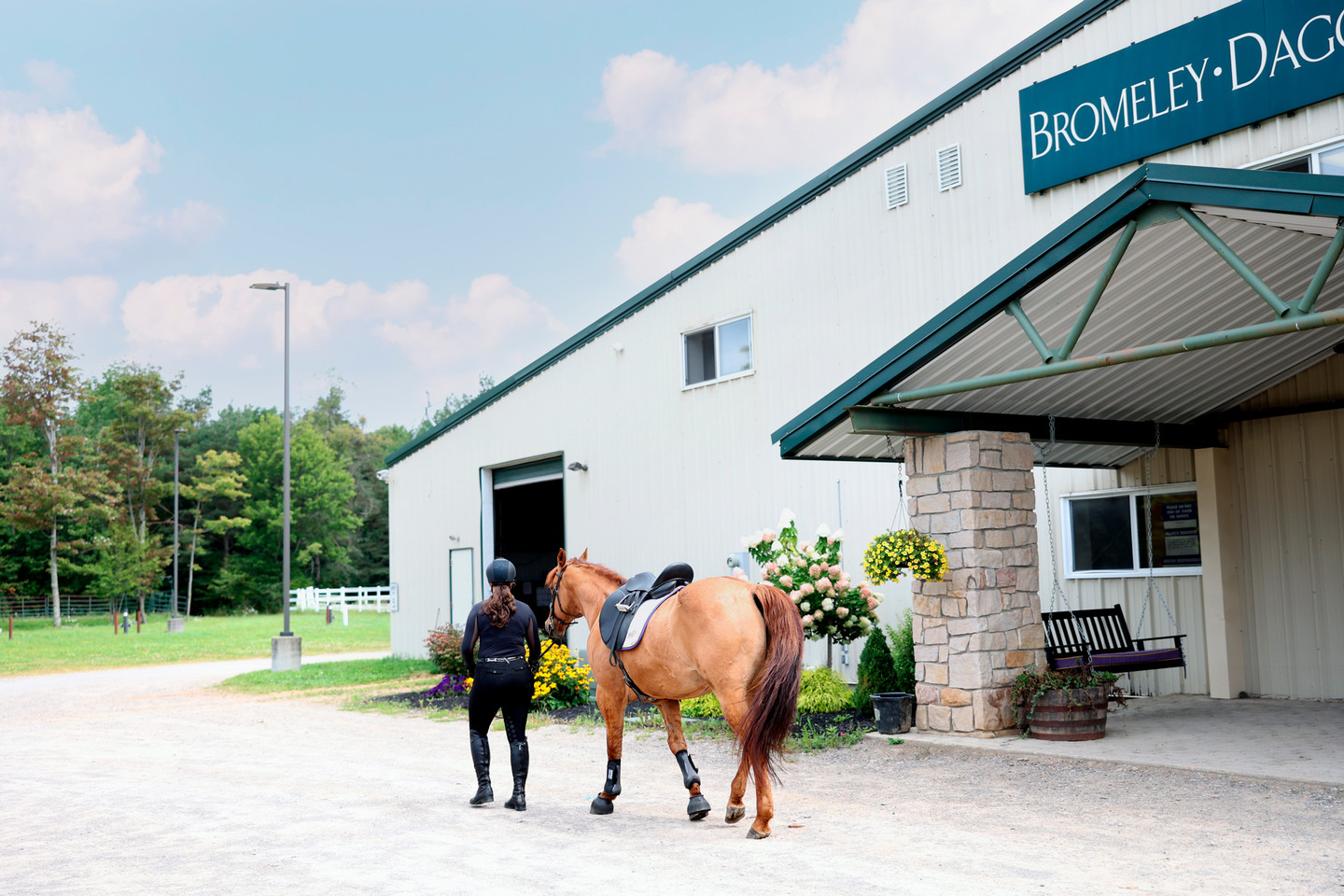 An equestrian student walking with a horse