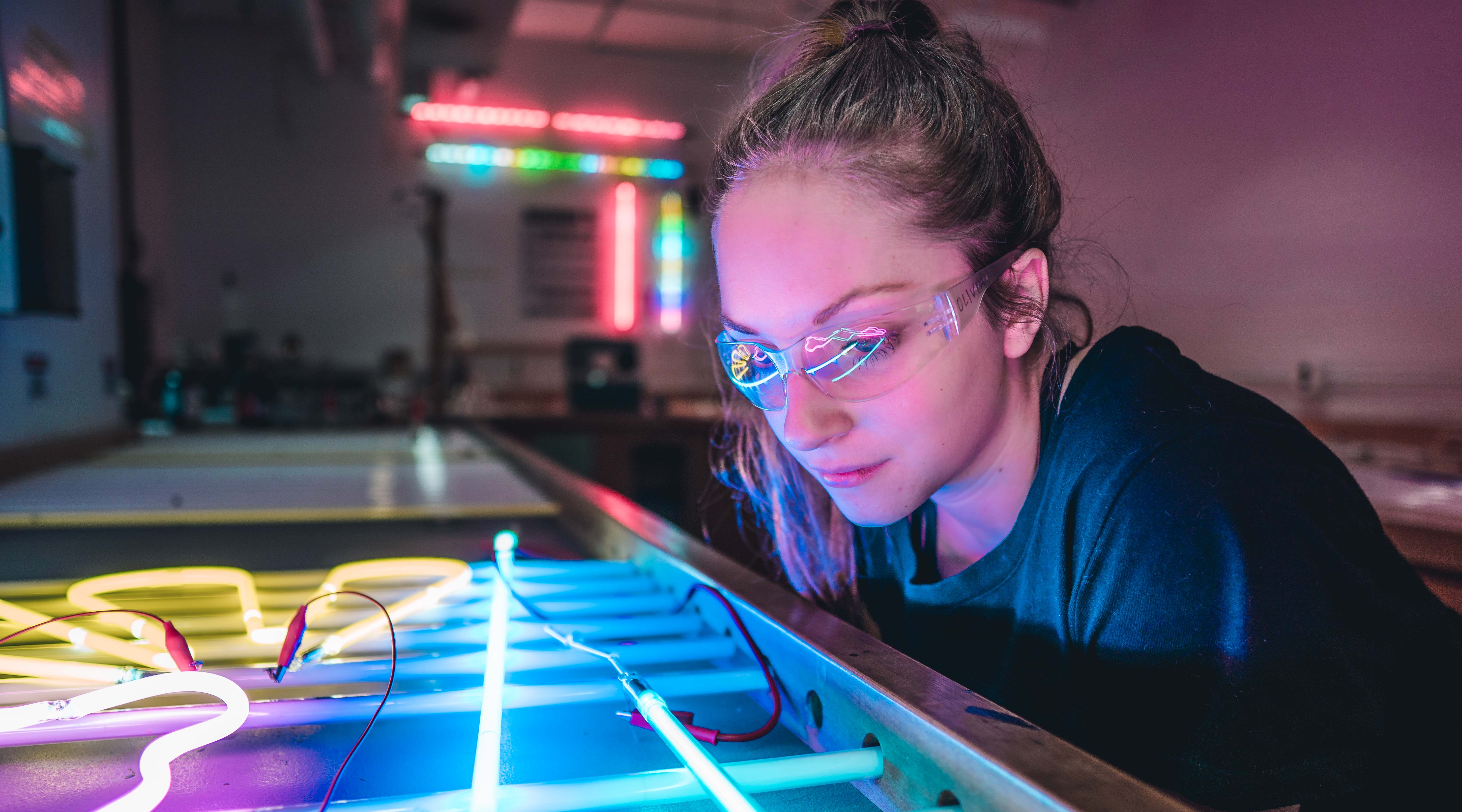 student looking at neon lights in the neon studio