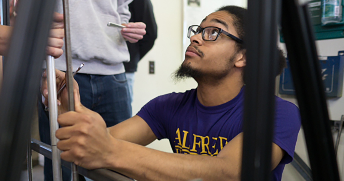 A photo of an Alfred University engineering student working in a lab