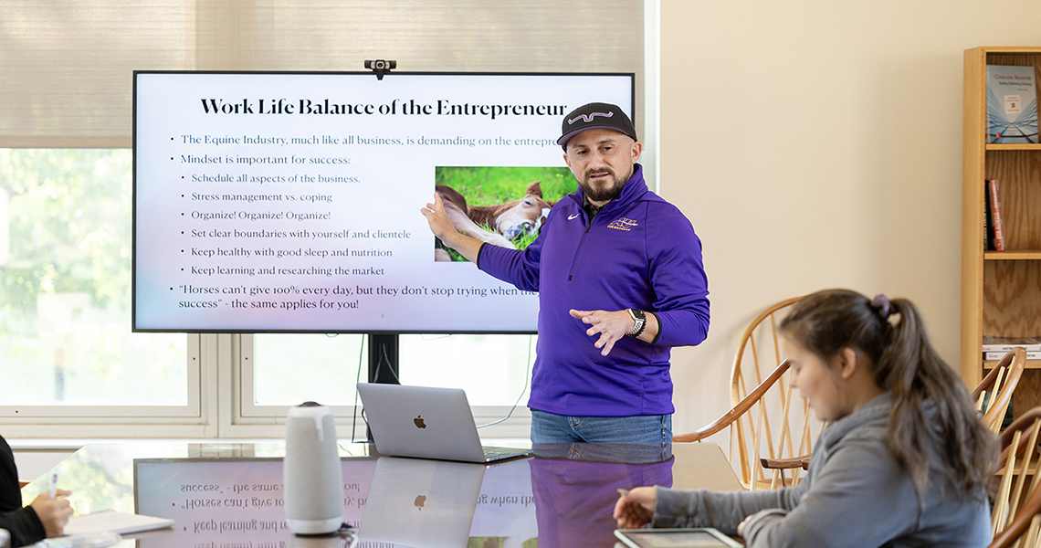 A photo of an Alfred University Equestrian faculty teaching a class on equine business management