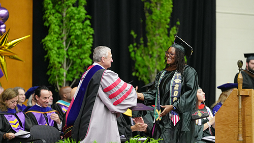A photo of President Zupan shaking hands with a student during Commencement