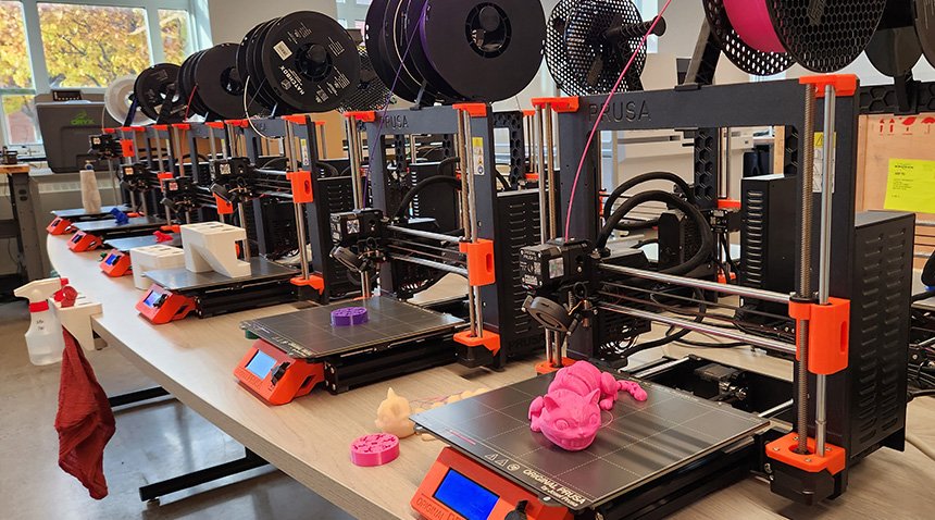 3d printers with plastic, printed toys on each in different fun colors