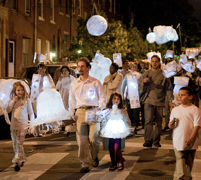 people walking down a street with lanterns