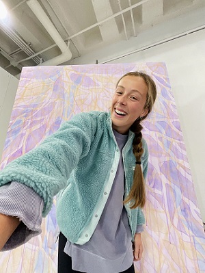 Ivy Vallely in front of one of her paintings