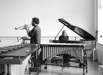 a pianist and trumpet player in a music studio