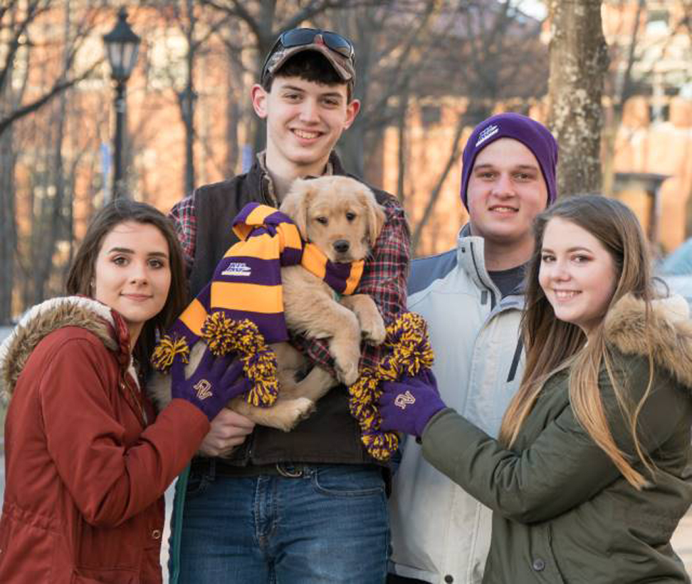 Students & puppy dressed in Alfred University gear