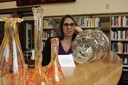 Denise Chilson, Director of the Hornell Public Library, with glass art donated by AU students