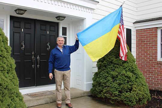 Mark Zupan with the United States and Ukrainian flags displayed at his residence in Alfred.