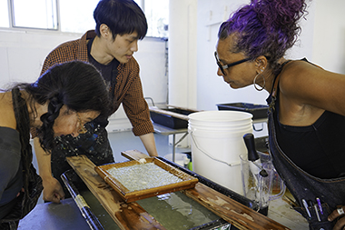 Patsy Rausch '92, far right, leads a workshop in papermaking