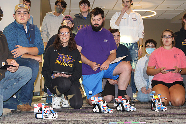 Engineering students operate robots they built and programmed