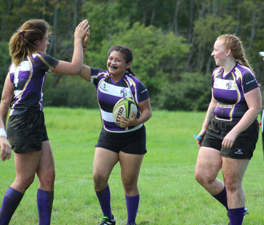 three women playing rugby