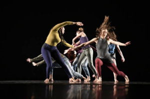 group of dancers on stage with dramtic lighting in dynamic poses