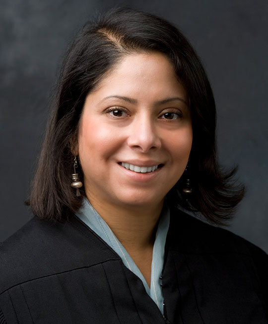 woman with dark hair wearing judge's robe